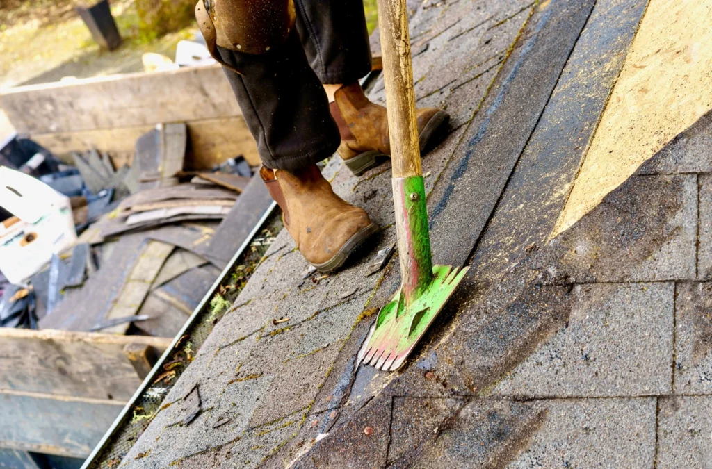 rooferusing a scraper to remove old shingles