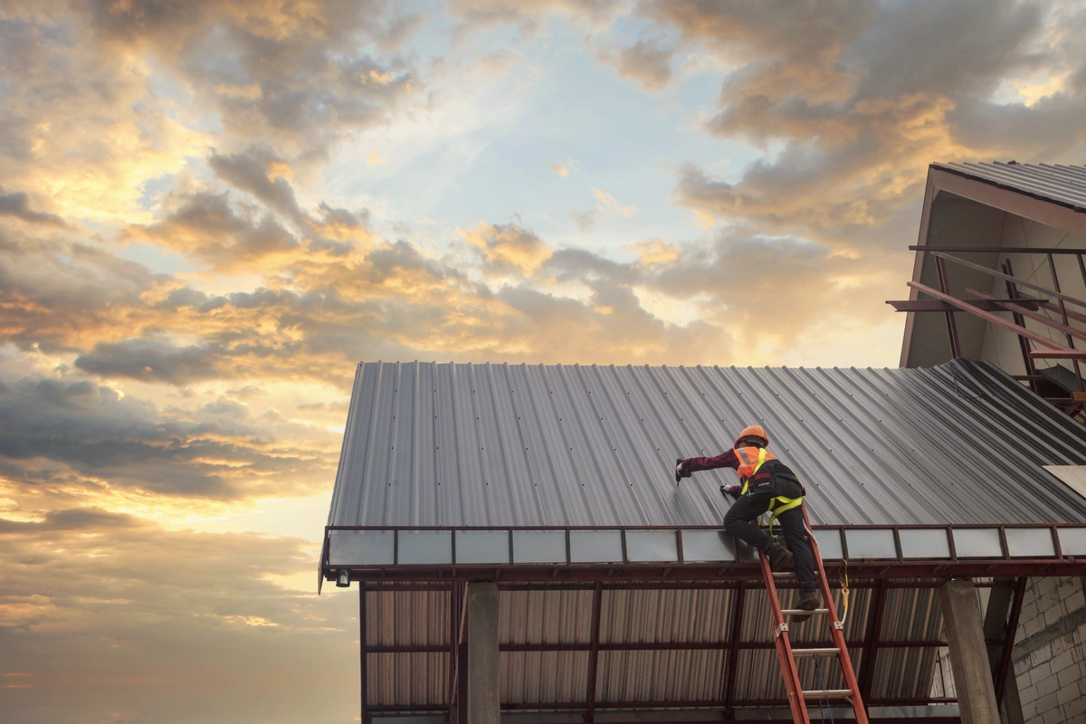 working on a metal roof at sunset