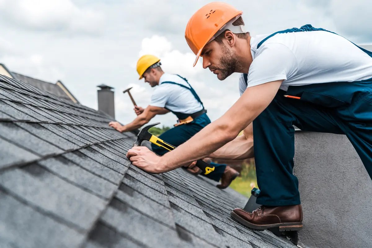 two roofers working hard