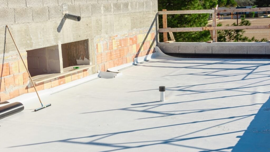 Worker applies pvc membrane one commercial building roof