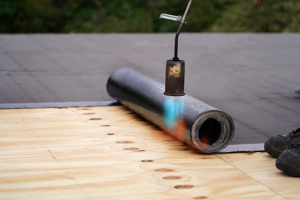 Bitumen roofing being installed on commercial roof