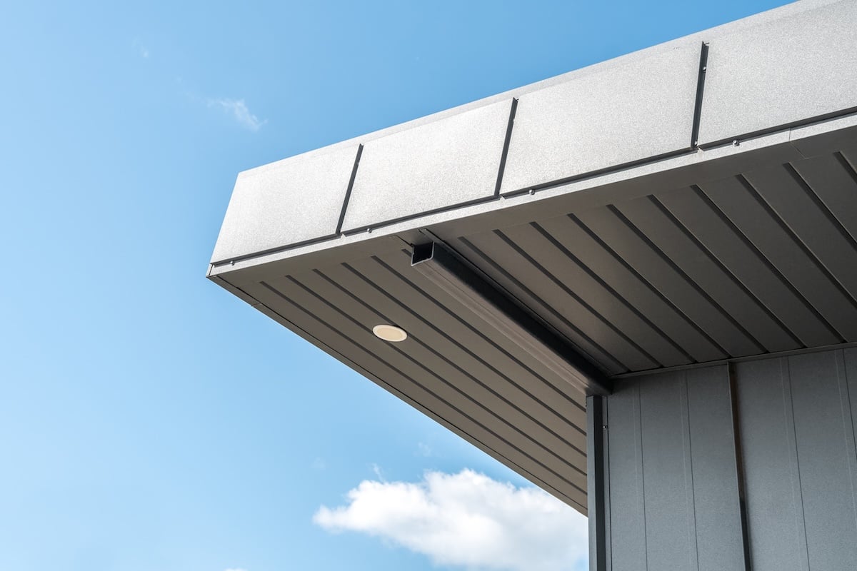 Modern house with standing seam facade and large flat roof overhang