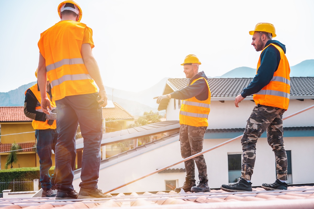 Team of workers work on a roofing project together