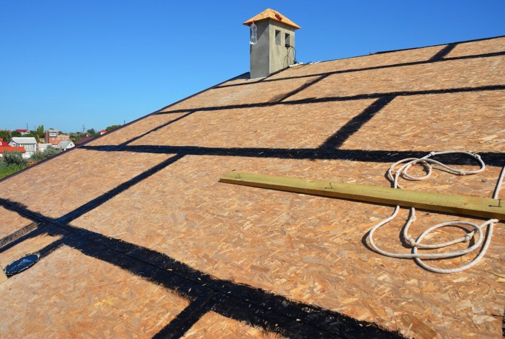 A close-up on an incomplete roofing construction on the stage of roof sheathing with self-adhering rubberized asphalt flexible flashings installed.
