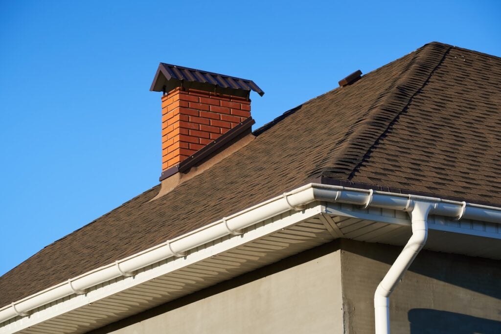 new roof and house under construction with chimney and rain cap