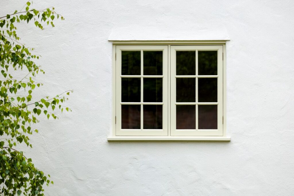 white house with a beige window next to a tree