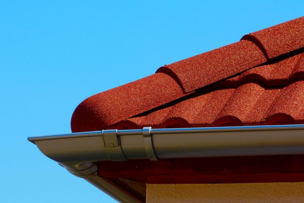 half round ridge tiles and shallow zink gutter in grey silver color.